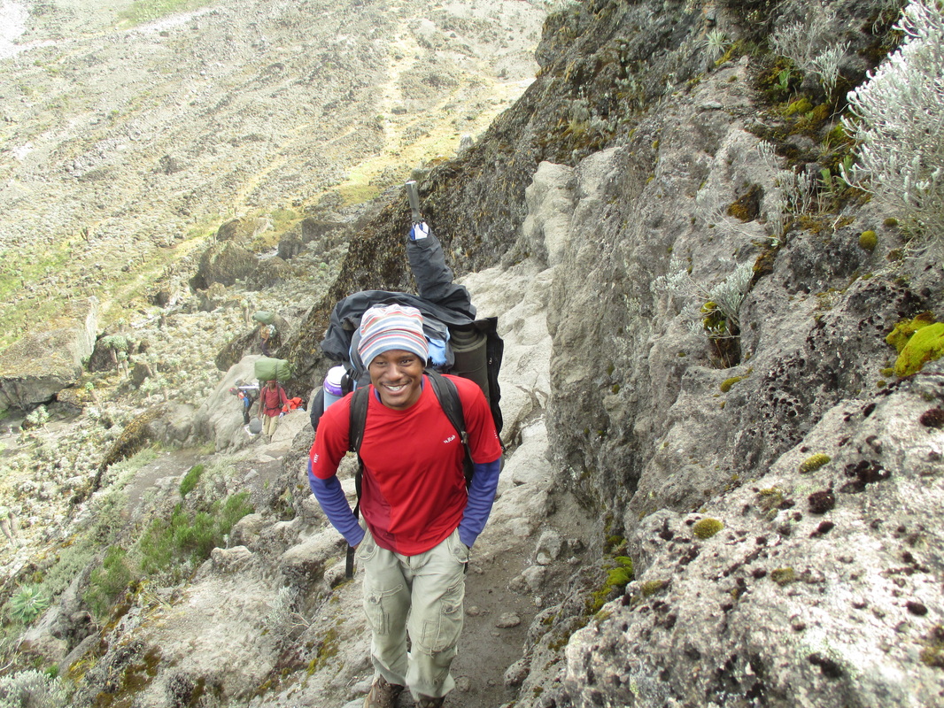 A Kilimanjaro guide, making his way up Kilimanjaro's Barranco Wall.  Climb Kilimanjaro with Samba Treks, a social enterprise.